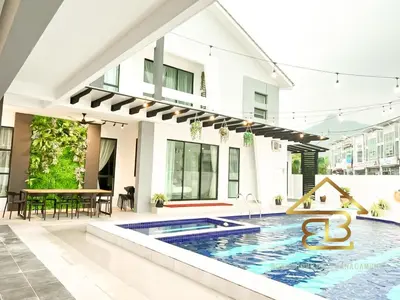 a villa with a swimming pool in front of a house at Ipoh Fairy Villa 3 Pool, Jacuzzi & KTV 23 Pax in Ipoh