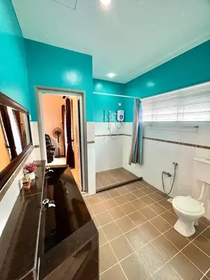 a bathroom with a toilet and a blue wall at Ipoh Sky Pool Villa, 20 Pax with Kbox, Gym & BBQ in Ipoh