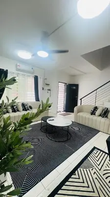 a living room with a couch and a table on a rug at D'Zebra Homestay Tambun in Kampong Batu Lapan