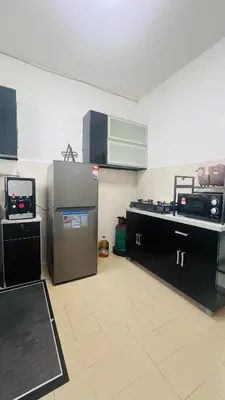 a kitchen with a refrigerator and a tv in it at D'Zebra Homestay Tambun in Kampong Batu Lapan