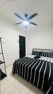 a bedroom with a black and white bed and a ceiling fan at D'Zebra Homestay Tambun in Kampong Batu Lapan