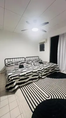 a bedroom with two beds and a ceiling fan at D'Zebra Homestay Tambun in Kampong Batu Lapan
