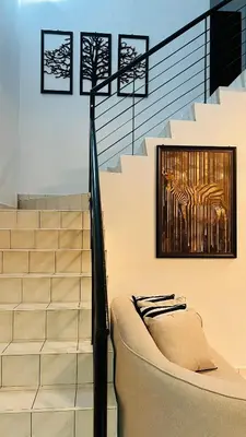 a couch sitting next to some stairs with a painting at D'Zebra Homestay Tambun in Kampong Batu Lapan