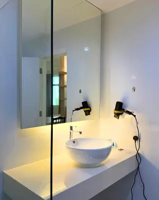 a bathroom with a white sink and a mirror at Stallions Suite Penang in Jelutong