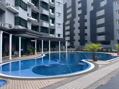 a large swimming pool in front of a building at Stallions Suite Penang in Jelutong