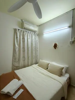 a bedroom with a bed with a ceiling fan at Tambun Apartment - Boho Natura in Tambun