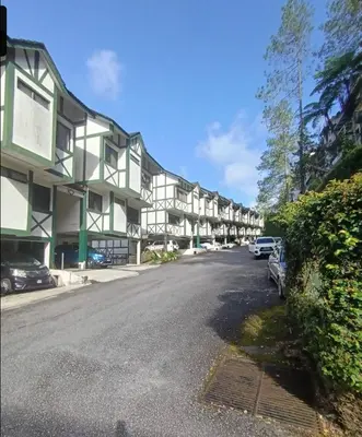 a building with cars parked on the side of a street at Homestay Cameron Highlands at Copthorne in Brinchang