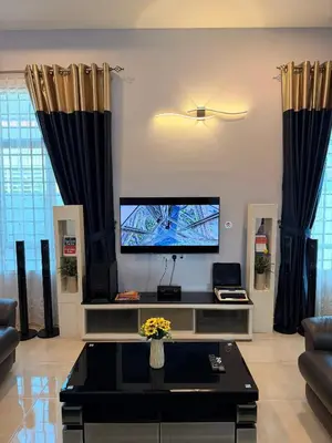 a living room with a tv and black curtains at PRS Bungalow Homestay in Ipoh