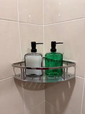 a glass shelf with two bottles on a wall at PRS Bungalow Homestay in Ipoh