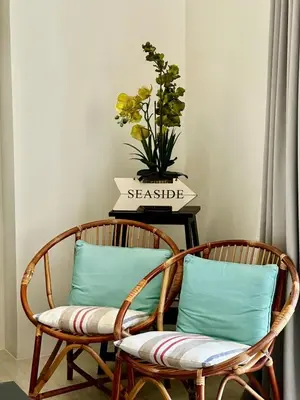 two chairs sitting next to a table with a vase of flowers at By The Sea partial seaview 2BR 6pax Batu Ferringhi in Batu Ferringhi