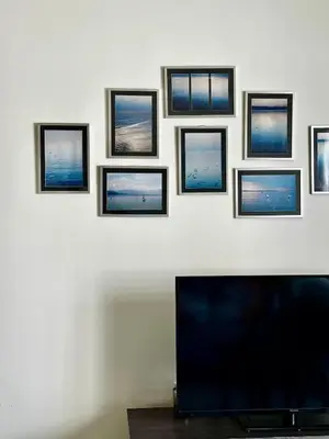 a wall with four pictures on a wall with a tv at By The Sea partial seaview 2BR 6pax Batu Ferringhi in Batu Ferringhi