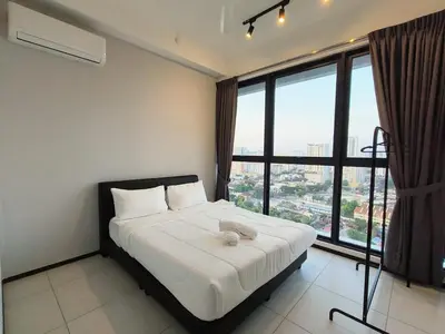 a bedroom with a bed and a large window at Urban Suites, Penang in George Town