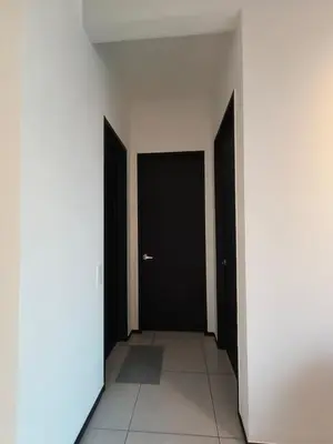 a hallway with two black doors and a tile floor at Urban Suites, Penang in George Town