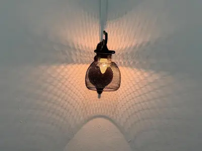 a light hanging from a wall with a shadow at Green Living Homestay Bercham 8 Pax in Ipoh