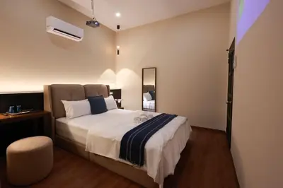 a bedroom with a large bed and a chair at The Cintra Muse Hotel at Central of Georgetown and UNESCO in George Town