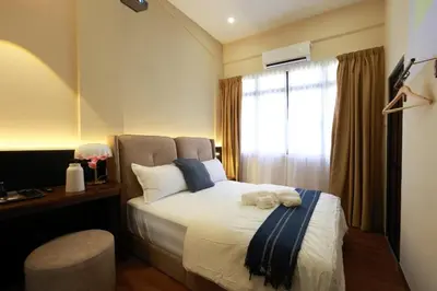 a bedroom with a bed and a desk and a window at The Cintra Muse Hotel at Central of Georgetown and UNESCO in George Town