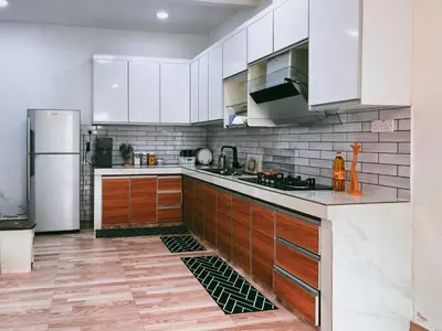 a kitchen with white cabinets and a refrigerator at Manjung Cozy Stay in Seri Manjung