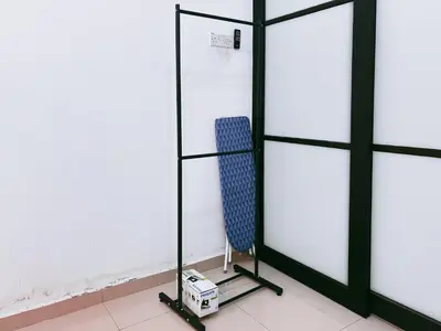 a room with a mirror and a blue chair at Manjung Cozy Stay in Seri Manjung