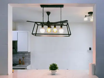 a black chandelier in a white kitchen with a plant at Manjung Cozy Stay in Seri Manjung