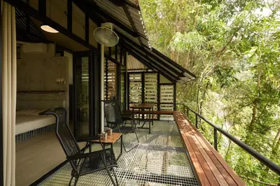 a screened in porch of a house with chairs and a bed at Stunning Mountain View Lodge with Pool Lauhaus2 in Kuala Kubu Baharu