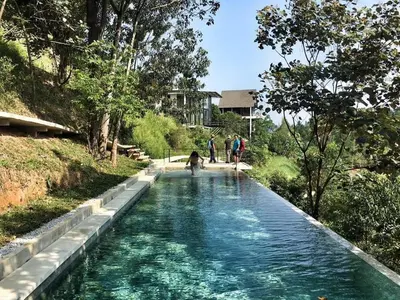 a pool of water with people and a dog on it at Stunning Mountain View Lodge with Pool Lauhaus2 in Kuala Kubu Baharu
