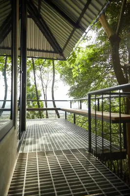 a walkway in a building with trees in the background at Stunning Mountain View Lodge with Pool Lauhaus2 in Kuala Kubu Baharu