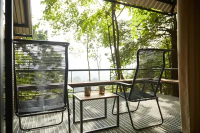 a patio with a table and chairs on a balcony at Stunning Mountain View Lodge with Pool Lauhaus2 in Kuala Kubu Baharu