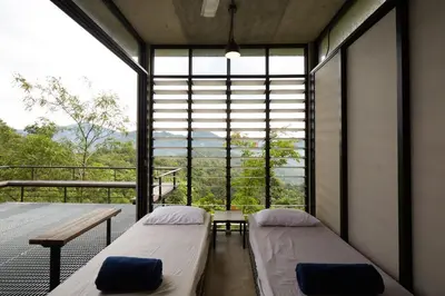 two beds in a room with a large window at Mountain View Getaway House with Pool Lauhaus 1 in Kuala Kubu Baharu