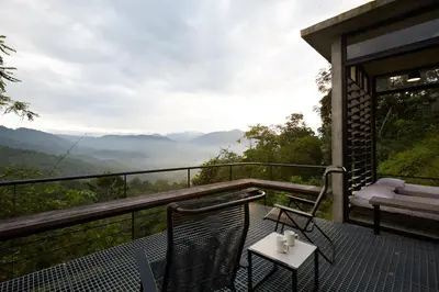 a balcony of a house with a table and chairs at Mountain View Getaway House with Pool Lauhaus 1 in Kuala Kubu Baharu