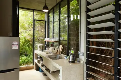 a kitchen with a sink and a glass wall at Mountain View Getaway House with Pool Lauhaus 1 in Kuala Kubu Baharu