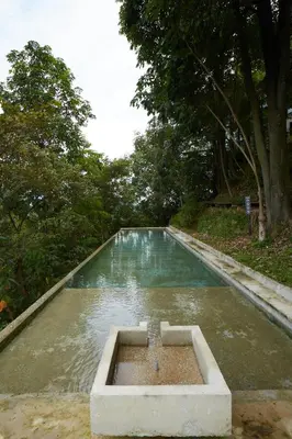 a pool of water in a field with trees at Mountain View Getaway House with Pool Lauhaus 1 in Kuala Kubu Baharu