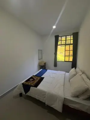 a bedroom with a large bed and a window at White rose Vila Taman sedia in Tanah Rata