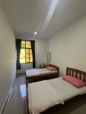 a room with two beds and a window at White rose Vila Taman sedia in Tanah Rata