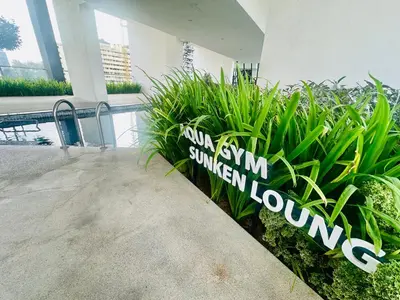 a sign in front of some plants in a building at Urban Suites 3R2B 11pax Deluxe Living Room in George Town