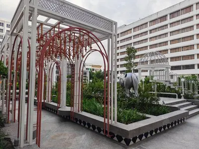 a garden with a statue of an elephant and a building at The Stallionz Classy Suites by LH - Ipoh Town in Ipoh