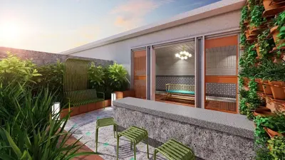 a patio with green chairs and a table at Stallionz by KLIQ in Ipoh