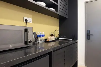 a kitchen with a counter top with a microwave at Stallionz by KLIQ in Ipoh