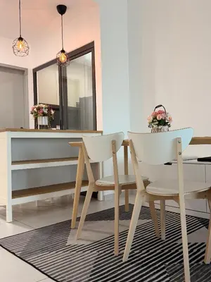 a dining room with a table and two chairs at Doksini in Simpang Ampat