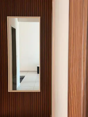 a mirror on a wooden wall with a hallway at Doksini in Simpang Ampat