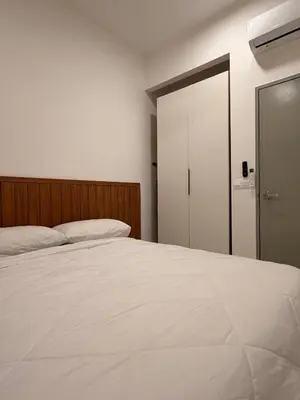 a bedroom with a white bed and a closet at Doksini in Simpang Ampat