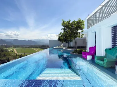 a swimming pool with chairs on the side of a house at Stallionz Leisure Suites Ipoh in Ipoh