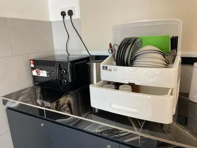 a kitchen counter with a container of dishes and a microwave at Piccadilly Greentown Ipoh in Ipoh