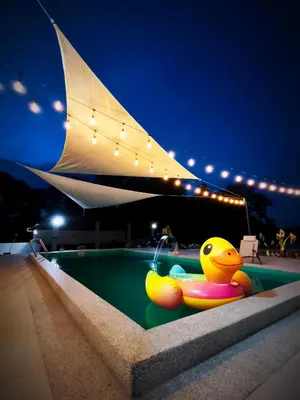 a yellow rubber duck sitting in a pool at night at Ipoh Santorini Pool Villa 4BR 15pax by One Life Four Season Guesthouse in Ipoh