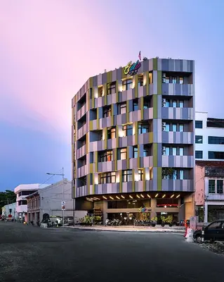 a tall building with a flag on top of it at Tido Hostel Penang in George Town