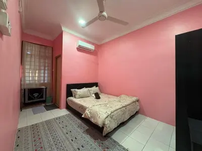 a bedroom with pink walls and a bed at Amiradanial Homestay in Gua Musang