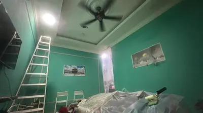 a bedroom with a ceiling fan and a green wall at RSyifaris ZH Homestay DSerai Wangi