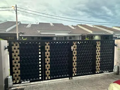 a black fence in front of some houses at RSyifaris ZH Homestay DSerai Wangi