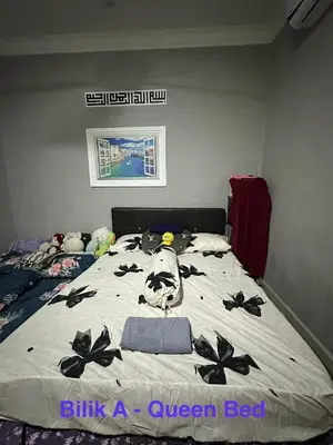 a bedroom with a bed with black flowers on it at RSyifaris ZH Homestay DSerai Wangi