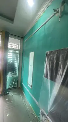 a room with a blue wall and a window at RSyifaris ZH Homestay DSerai Wangi