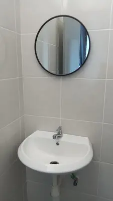 a bathroom with a white sink and a mirror at Rara Homestay in Kampong Selamat